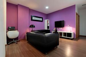 巴塞罗那BCN尼茨旅馆的紫色的客房配有沙发和电视