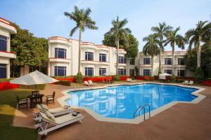 克久拉霍华美达克久拉霍酒店的一座拥有游泳池、椅子和棕榈树的酒店
