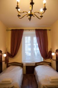桑多梅日Apartament Parkowy的配有窗户和吊灯的客房内的两张床