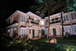 科尔瓦优雅色调公寓的一座白色的大房子,晚上种有棕榈树