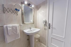 拉克鲁斯太阳假日酒店的白色的浴室设有水槽和镜子