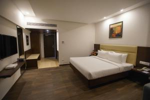 钦奈Jaag Hotel的酒店客房,配有床和电视
