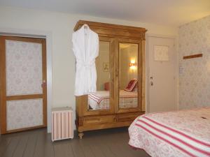 鲁汶Guesthouse Alizée的一间卧室配有一张床和挂着的连衣裙