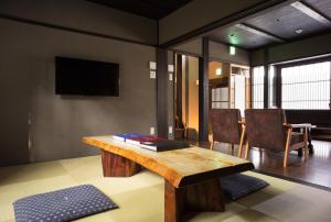 京都丽阁八坂的客厅配有木桌和电视。