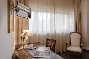 卡斯特里尼亚诺德尔卡波拉奇欧西拉酒店的客房设有桌子、椅子和窗户。