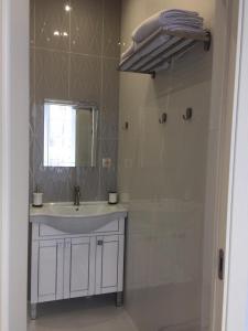 MakīnskScandi Hotel的浴室配有盥洗盆和带镜子的淋浴