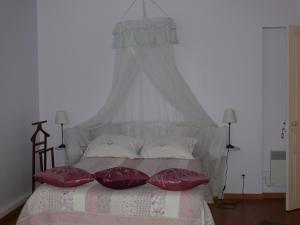 圣艾米隆Les Oiseaux的一间卧室配有一张带红色枕头的床
