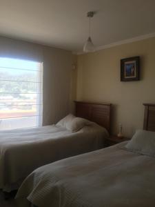 特木科Departamento 606的配有窗户的酒店客房内的两张床