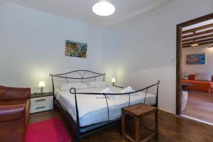杜布罗夫尼克Apartment Hladilo "Nostalgia"的一间卧室配有一张床、一把椅子和一张沙发