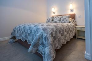 布莱克浦Stay的一间卧室配有一张带蓝色和灰色毯子的床