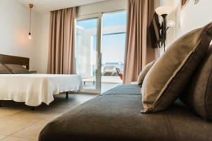 萨阿拉德洛斯阿图内斯Apartamentos ZHR的酒店客房设有一张床和一个大窗户