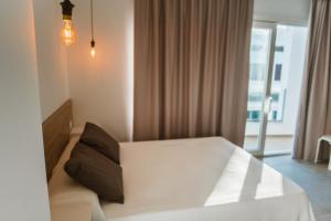 萨阿拉德洛斯阿图内斯Apartamentos ZHR的卧室配有白色的床和窗户。