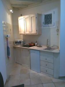奥里亚Elisea House的小厨房配有白色橱柜和水槽