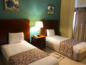 辛普森湾卡尔别致酒店及会议设施的酒店客房,设有两张床和一盏灯
