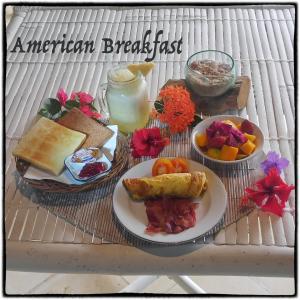 乌鲁瓦图宾敬迎宾旅馆的一张桌子,上面放着一盘早餐食品和饮料