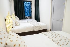 东京Blue Empire Hotel的配有白色床单的客房内的三张床