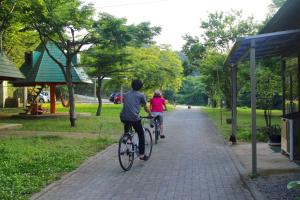 Bungoono清川旅舍 的骑着自行车沿着人行道走的男人和女人