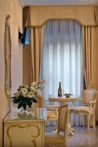 威尼斯艾尔马尔卡通酒店的客厅配有桌椅和窗户。