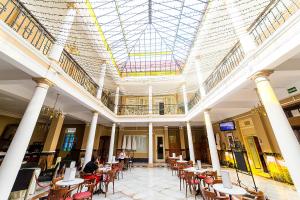拉拉古纳Hotel Aguere的大堂设有桌椅和天花板。