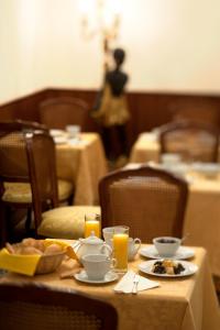威尼斯艾尔马尔卡通酒店的餐桌,带食物盘和橙汁杯