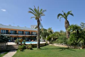 阿尔贝罗贝洛库尔迪普利亚酒店的棕榈树和游泳池度假村