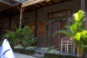 坎古Tropical Canggu Hostel的一座带木门、桌子和椅子的房子