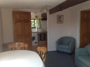 考斯New Stable Cottage的客厅配有桌子和椅子