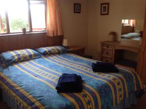 考斯New Stable Cottage的一间卧室,配有一张带两个袋子的床