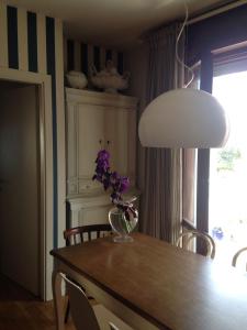 法诺LA CASA DEL MARE的一张餐桌,上面有紫色花瓶