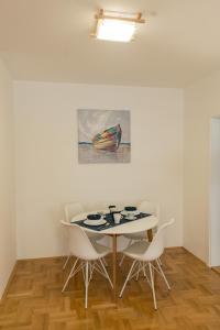 瓦列沃Apartmani Hemera的一间带桌椅和绘画的用餐室
