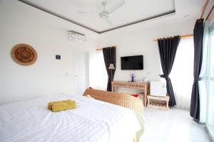 金巴兰Vanilla Suite Jimbaran的一间白色卧室,配有床和电视