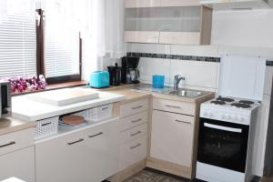 帕恩多夫Holiday House Huszar的厨房配有白色橱柜和白色炉灶烤箱。