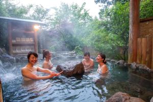 南小国町Kurokawa Mori no Cottage的一群人在热水浴缸中
