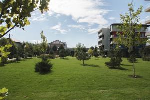 奥托佩尼Airport Residence - Across from Otopeni Airport的绿树成荫的公园和建筑