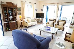 瓦西Villa Marika的客厅配有蓝色的沙发和椅子