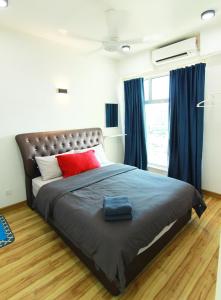 哥打巴鲁10:39 Studio @ D'Perdana Sri Cemerlang的一间卧室配有一张大床,配有红色枕头和蓝色窗帘