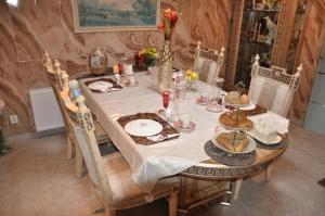 代尔夫宰尔Bed & Breakfast Rita的餐桌、白色桌布和椅子