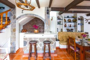 埃尔博斯克Hacienda El Molino的厨房配有石制壁炉、桌子和凳子