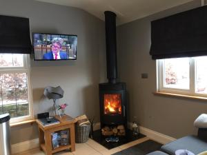 彭里斯Summer House, Glassonby的客厅设有壁炉和墙上的电视