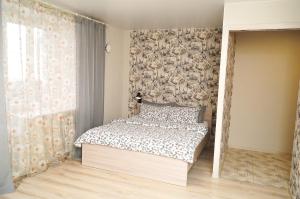 沃洛格达雅罗斯拉夫尔普雷米尼纳科瓦迪金公寓的一间卧室配有一张带花卉壁纸的床