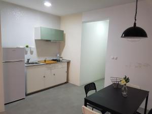 明德卢Casa Io - Djeu的厨房配有黑桌和冰箱。
