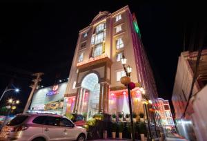 Ap Rạch SoiPhuc Ngoc Hotel的停在有 ⁇ 虹灯的建筑前的汽车