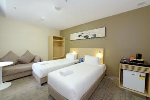 墨尔本墨尔本中央商务区宜必思快捷酒店的酒店客房,设有两张床和一张沙发