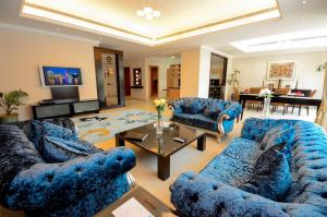 迪拜珊瑚精品别墅酒店的客厅配有2张蓝色的沙发和1张桌子