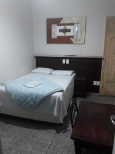 阿拉萨图巴阿拉卡酒店的卧室配有一张床铺,位于带桌子的房间