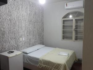 阿拉萨图巴阿拉卡酒店的一间小卧室,配有床和窗户