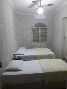 阿拉萨图巴阿拉卡酒店的一间带三张床和吊扇的卧室
