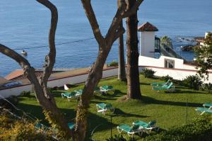 丰沙尔大金塔德弗兰卡酒店的一个带椅子的度假胜地,背景是大海