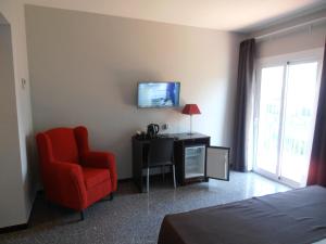 滨海托萨多萨德马尔酒店的酒店客房设有红色椅子和电视