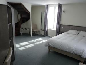 Sainte-SuzanneBeauséjour的一间卧室设有一张大床和一个楼梯间